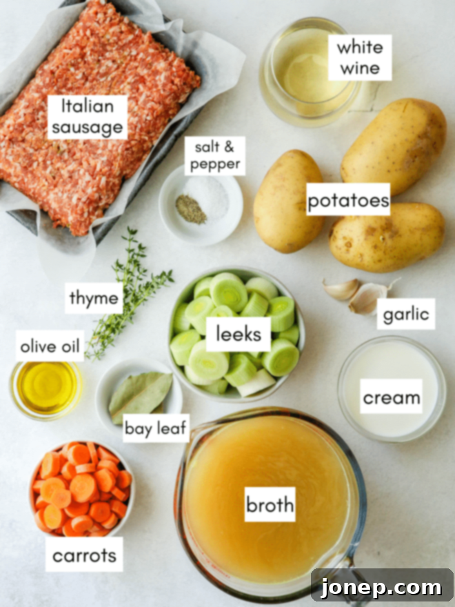 Rustic Italian Sausage & Leek Soup 4 A flat lay of fresh ingredients for potato leek and Italian sausage soup including leeks, carrots, potatoes, garlic, sausage, and herbs.