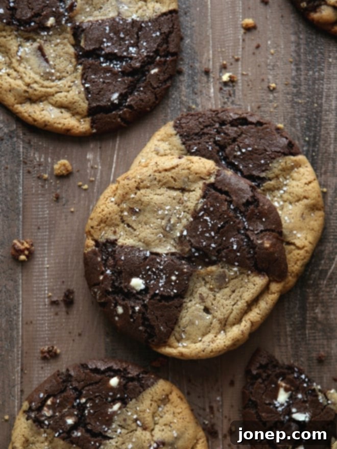 Close-up of a beautifully swirled Malted Chocolate Chip and Reverse Chip Cookie, showing the distinct dark and light dough patterns with chocolate chunks.