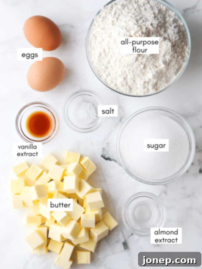 Festive Spritz Cookie Delights 3 A selection of essential ingredients for spritz cookies laid out on a kitchen counter: butter, sugar, eggs, flour, salt, and vanilla and almond extracts.