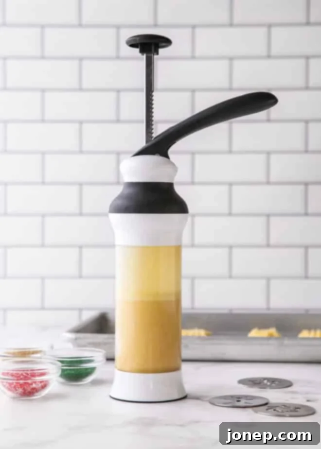 A cookie press cylinder filled with raw spritz cookie dough, ready for shaping.