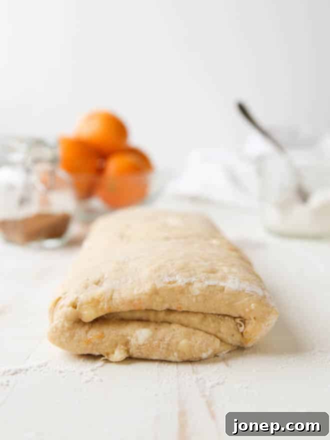 Several freshly baked Spiced Cranberry Orange Danishes on a parchment-lined baking sheet. | completelydelicious.com