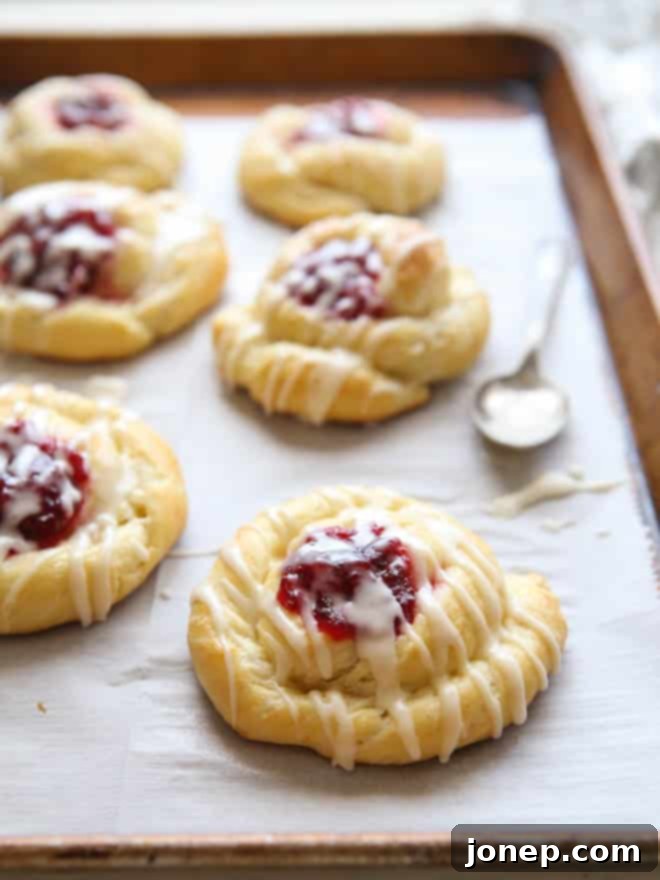 Spiced Cranberry Orange Danishes drizzled with a sweet orange glaze. | completelydelicious.com