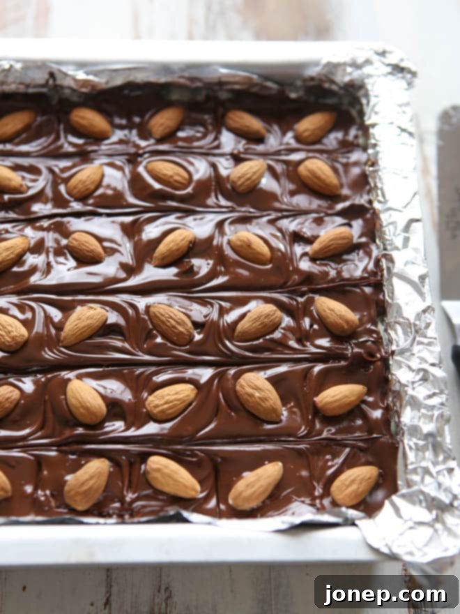 Finished Coconut Almond Fudge topped with whole almonds, ready for chilling