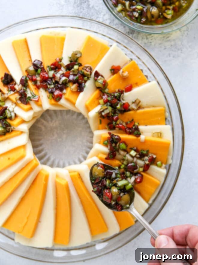 Zesty Marinated Cheese 5 Marinated cheese wreath on a platter, covered with plastic wrap, ready for chilling.