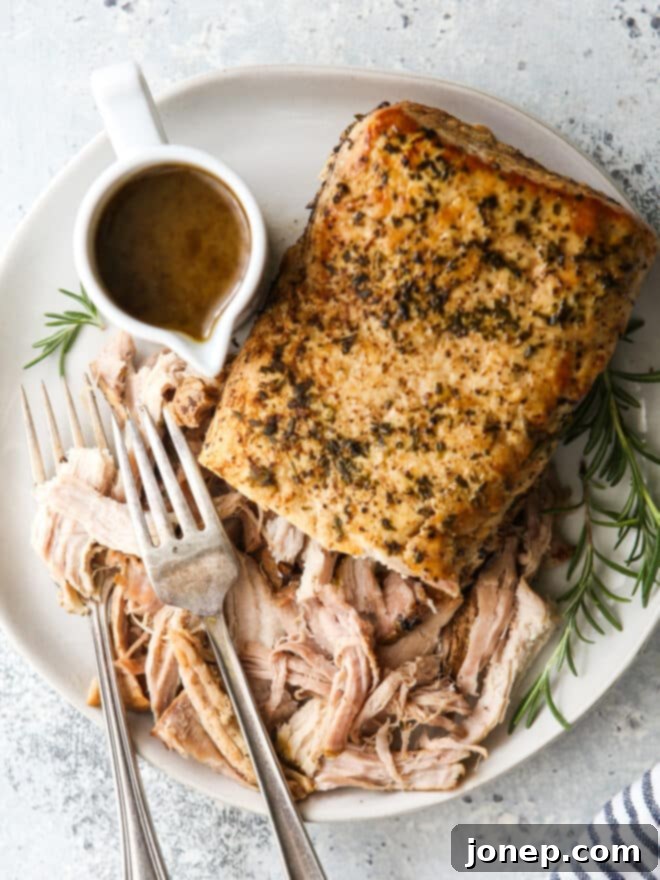 slow cooker rosemary balsamic pork roast shredded on a plate