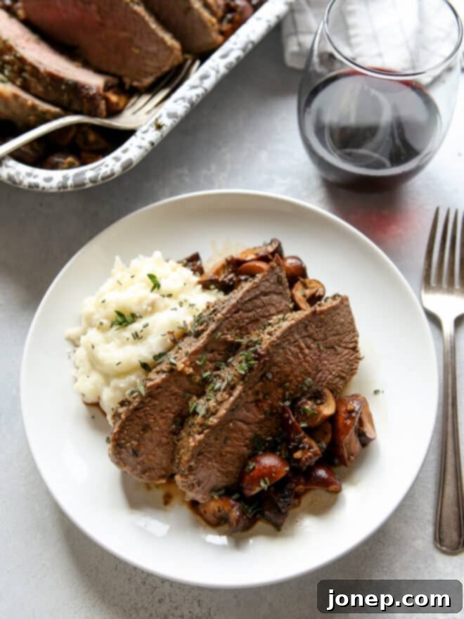 garlic and herb tri-tip roast with mushrooms on a plate
