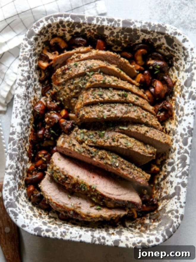 garlic and herb tri-tip roast with mushrooms sliced in baking dish