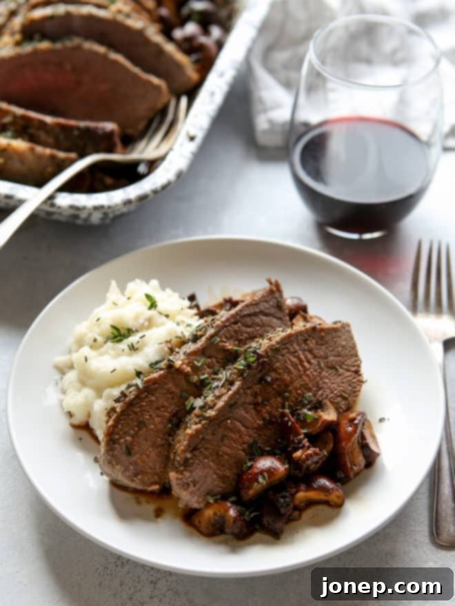 garlic and herb tri-tip roast with mushrooms on a plate