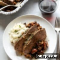 Savory Roasted Tri-Tip with Garlic Herb Mushrooms 7 garlic and herb tri-tip roast with mushrooms on a plate