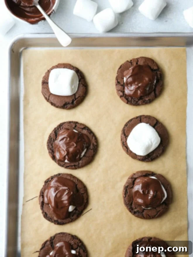 putting marshmallows and melted chocolate onto cookies