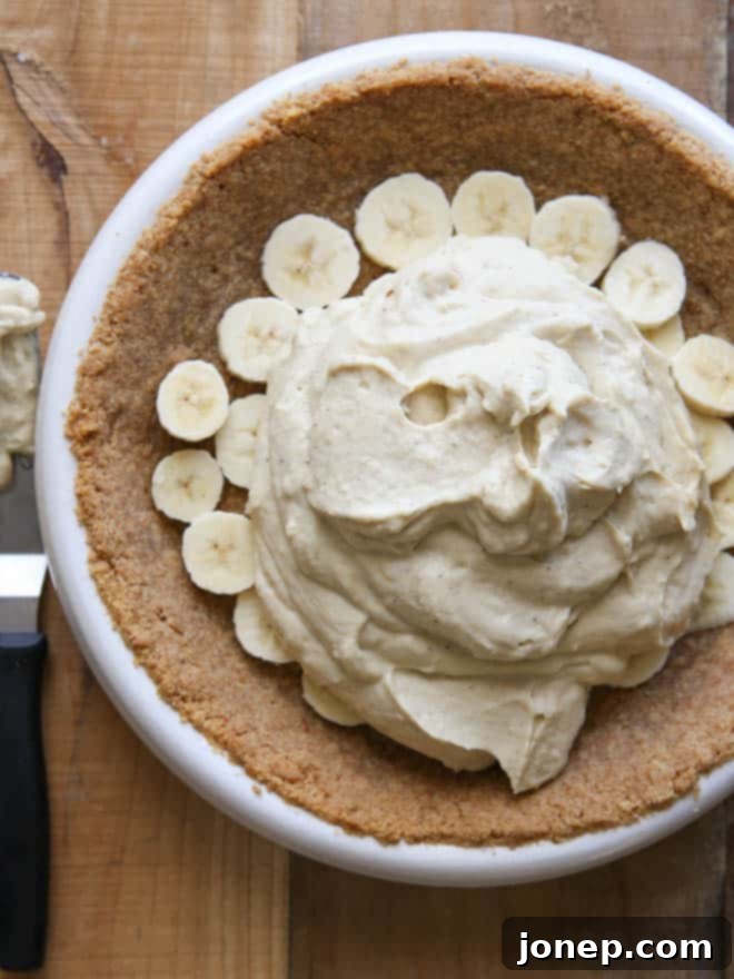 A whole Bourbon Banana Cream Pie in its vanilla wafer crust, showcasing its rich, golden-brown filling before adding toppings.