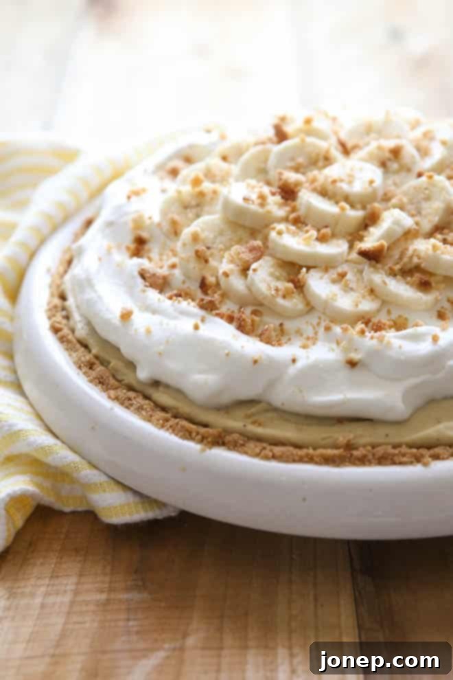 Beautifully presented slice of Bourbon Banana Cream Pie, showcasing its layers of crust, banana, creamy filling, and fluffy whipped topping.