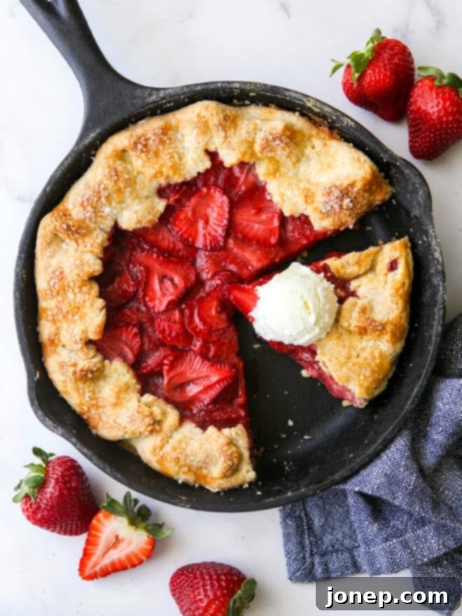 Rustic Strawberry Skillet Pie 2 sliced strawberry skillet pie with a scoop of vanilla ice cream on a slice of pie
