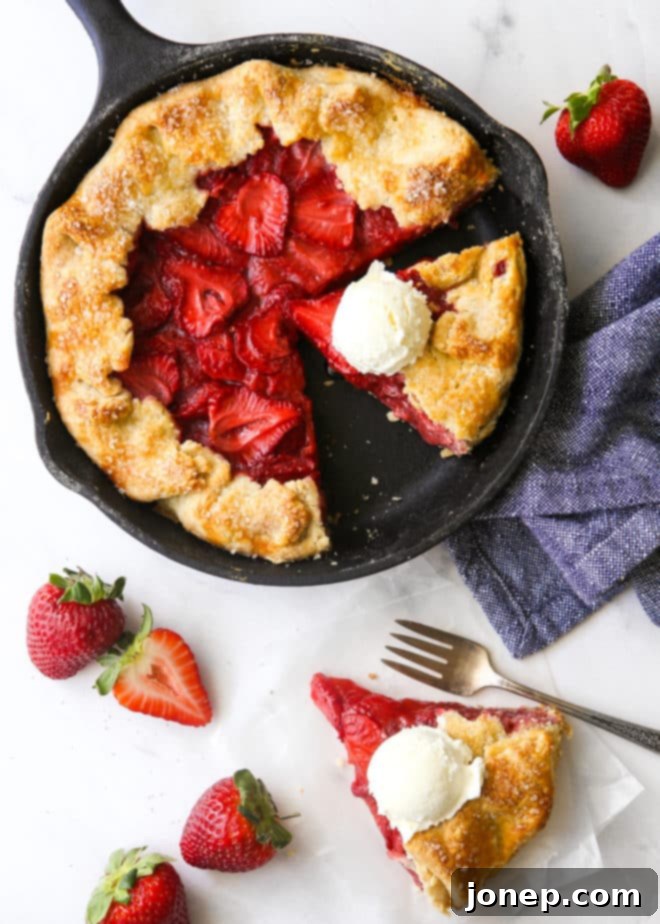 Rustic Strawberry Skillet Pie 7 strawberry skillet pie with a slice on the side, scoops of ice cream on top