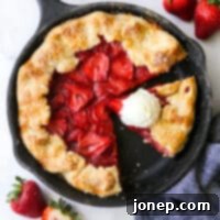 Rustic Strawberry Skillet Pie 8 sliced strawberry skillet pie with a scoop of vanilla ice cream on a slice of pie