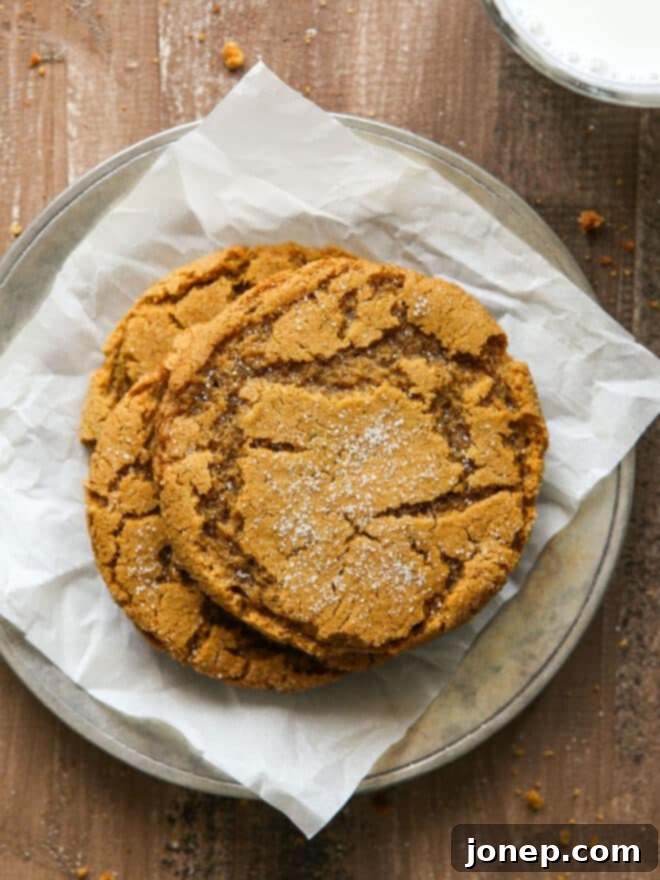 Soft-Baked Ginger Spice Cookies 2 stack of gingersnaps on a plate with glass of milk