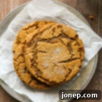 Soft-Baked Ginger Spice Cookies 7 stack of gingersnaps on a plate with glass of milk