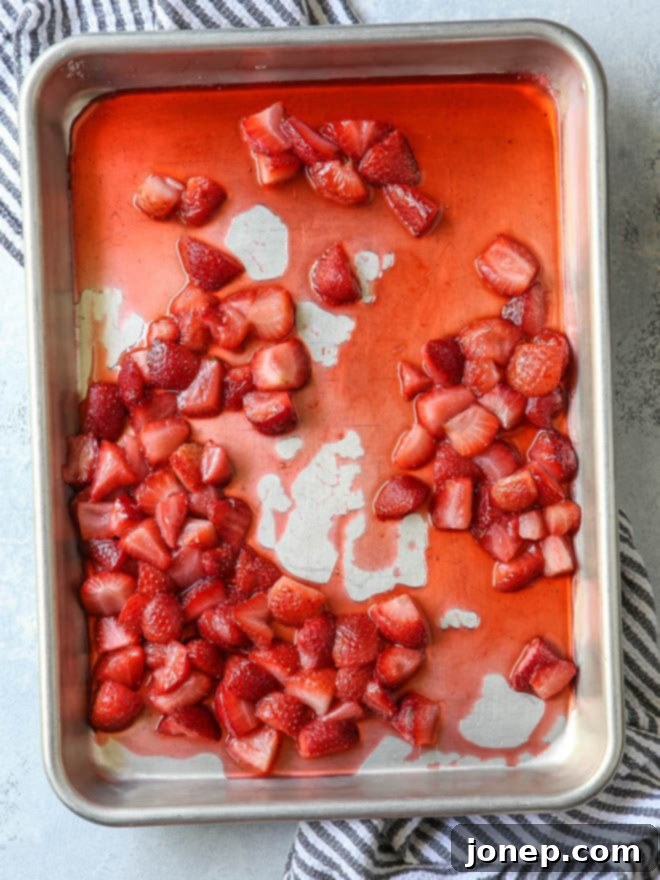 Close-up of roasted strawberries on a baking sheet, showcasing their rich color and caramelized juices.
