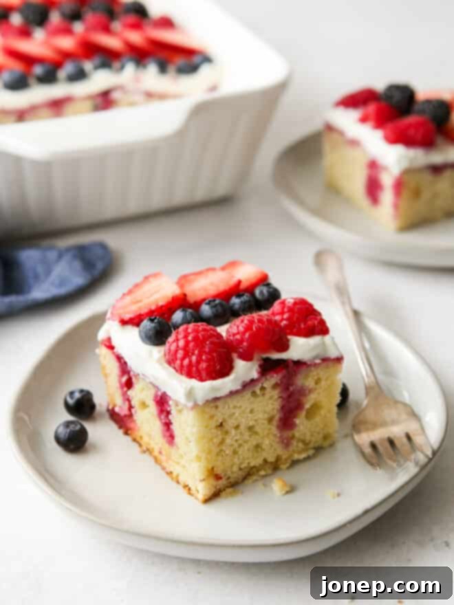 Berry Infusion Cake 2 Beautiful homemade berry poke cake topped with fresh berries and whipped cream, perfect for summer