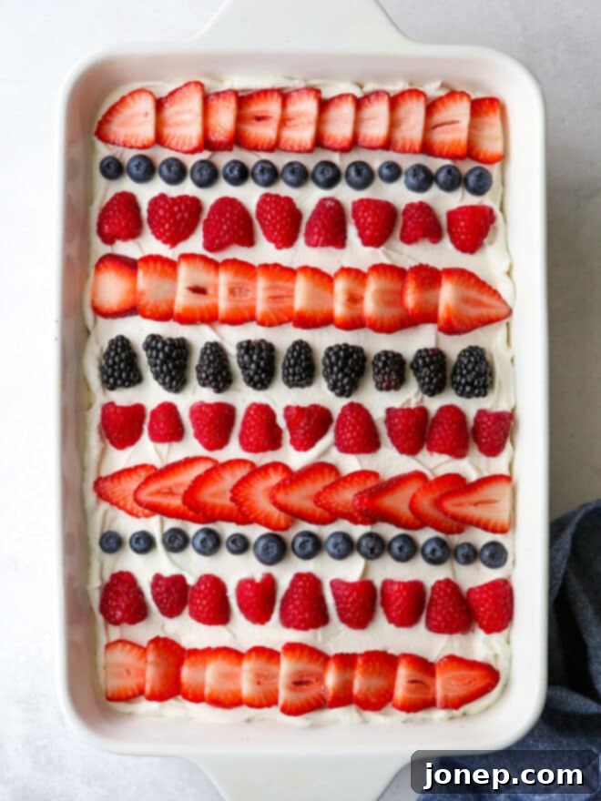 Berry Infusion Cake 9 A perfectly sliced piece of berry poke cake on a serving plate, showing off the berry filled tunnels