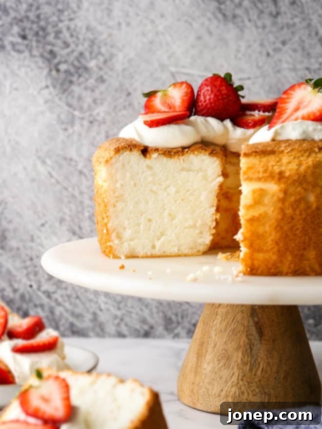 A close-up shot of an entire angel food cake displayed on a decorative cake stand, ready to be served.