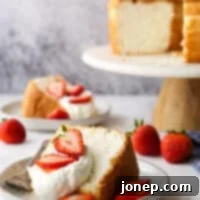closeup of angel food cake with whipped cream and strawberries on a plate