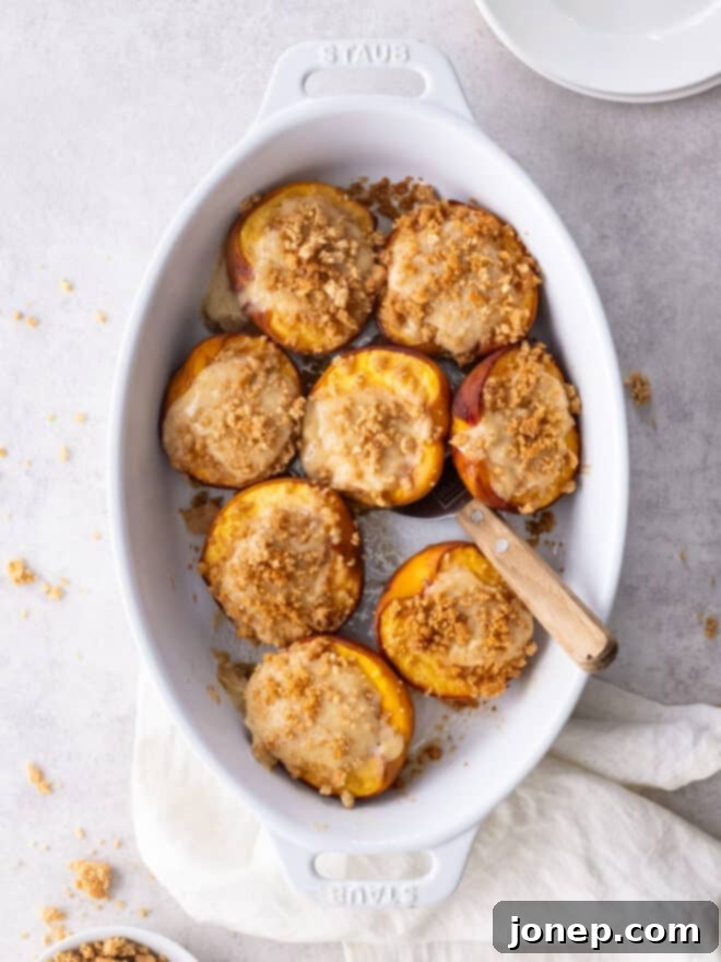 Cheesecake Stuffed Peaches with Graham Cracker Crumble 2 baking dish with baked cheesecake stuffed peaches
