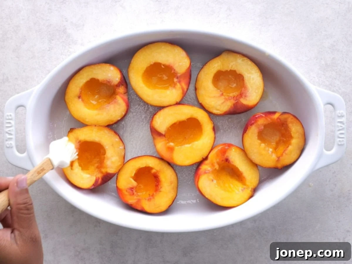 brushing halved peaches with butter
