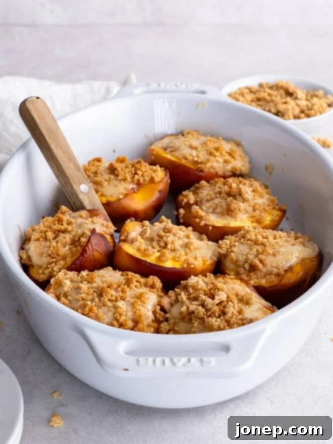 Cheesecake Stuffed Peaches with Graham Cracker Crumble 8 baked cheesecake stuffed peaches in baking dish