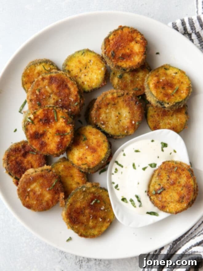 Dipping crispy fried zucchini in ranch dressing