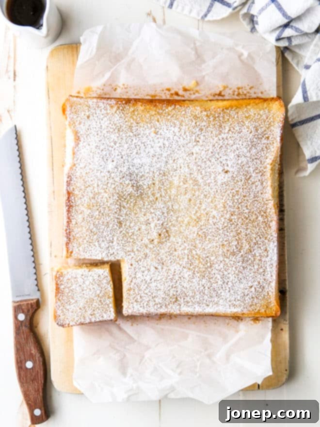 A close-up of a hand slicing golden maple butter bars on a wooden cutting board, revealing the two distinct layers: a crumbly crust and a creamy maple filling.