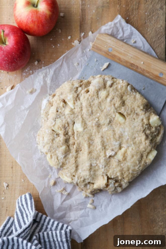 Dough for apple cinnamon scones being rolled out, showing preparation stage