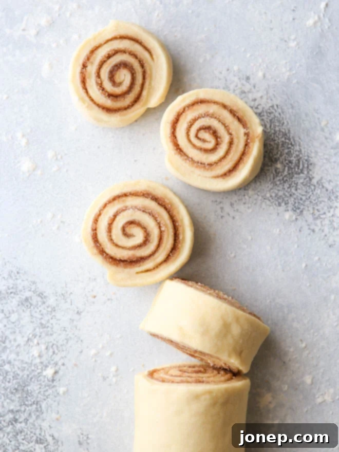 Individual cinnamon rolls, perfectly baked and frosted, ready to be pulled apart from the Christmas tree arrangement.