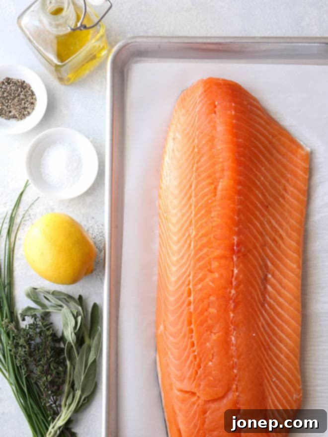 Easy Lemon Herb Roasted Salmon 4 Fresh lemon slices and herbs perfectly seasoned on a salmon fillet, ready for roasting.