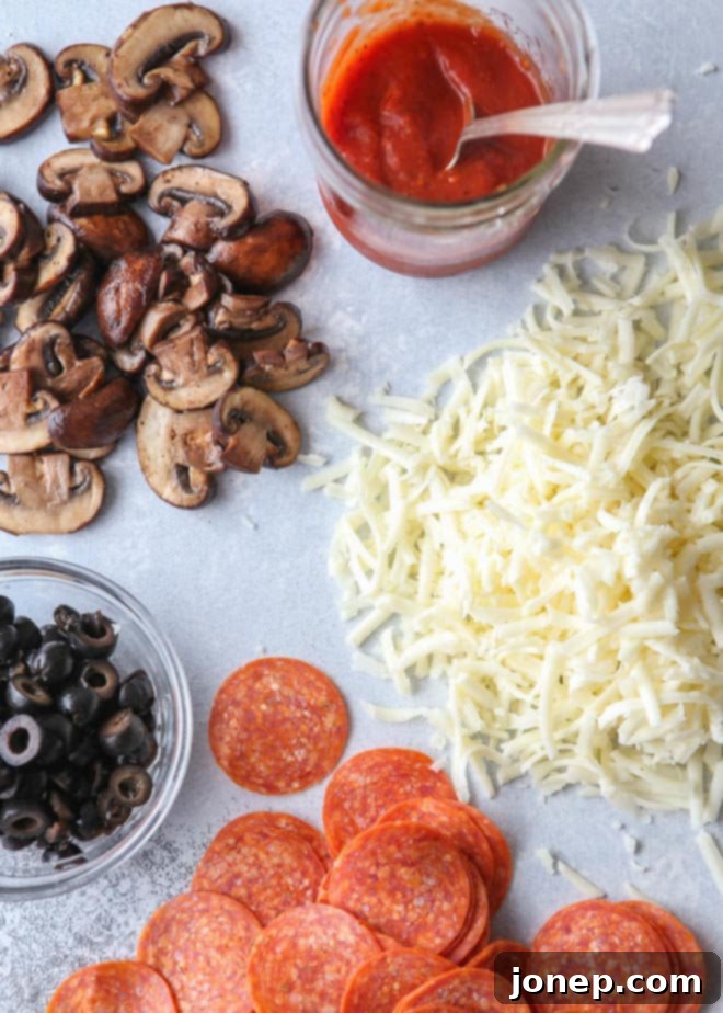 Ingredients laid out for making sheet pan pizza: dough, sauce, cheese, and toppings