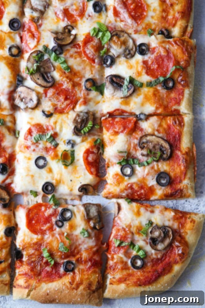 Close up of a finished sheet pan pizza, with a slice removed