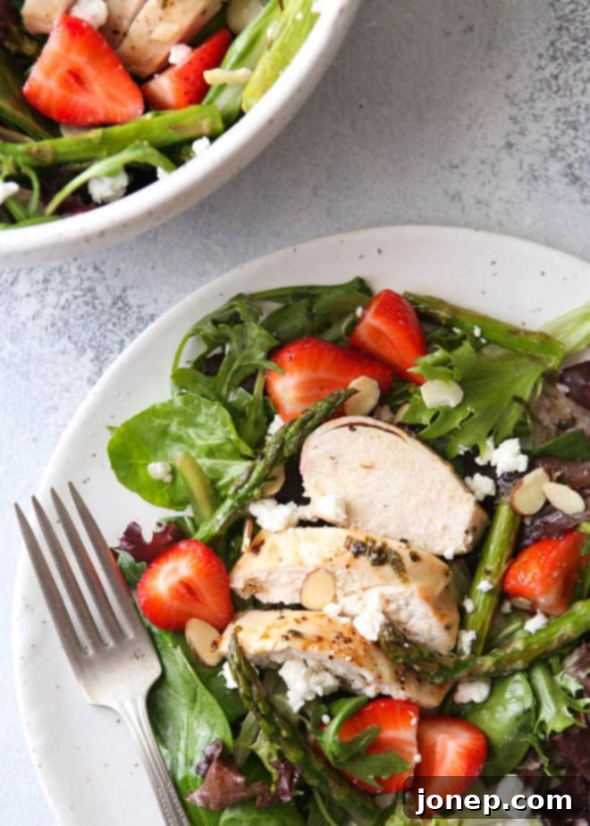 Gourmet strawberry asparagus salad with chicken served in a bowl, ready to enjoy.