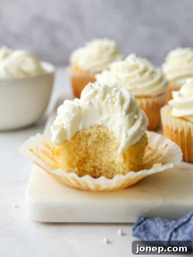 Classic Vanilla Cupcakes 3 Close-up of baked vanilla cupcakes in paper liners, showing their domed tops.