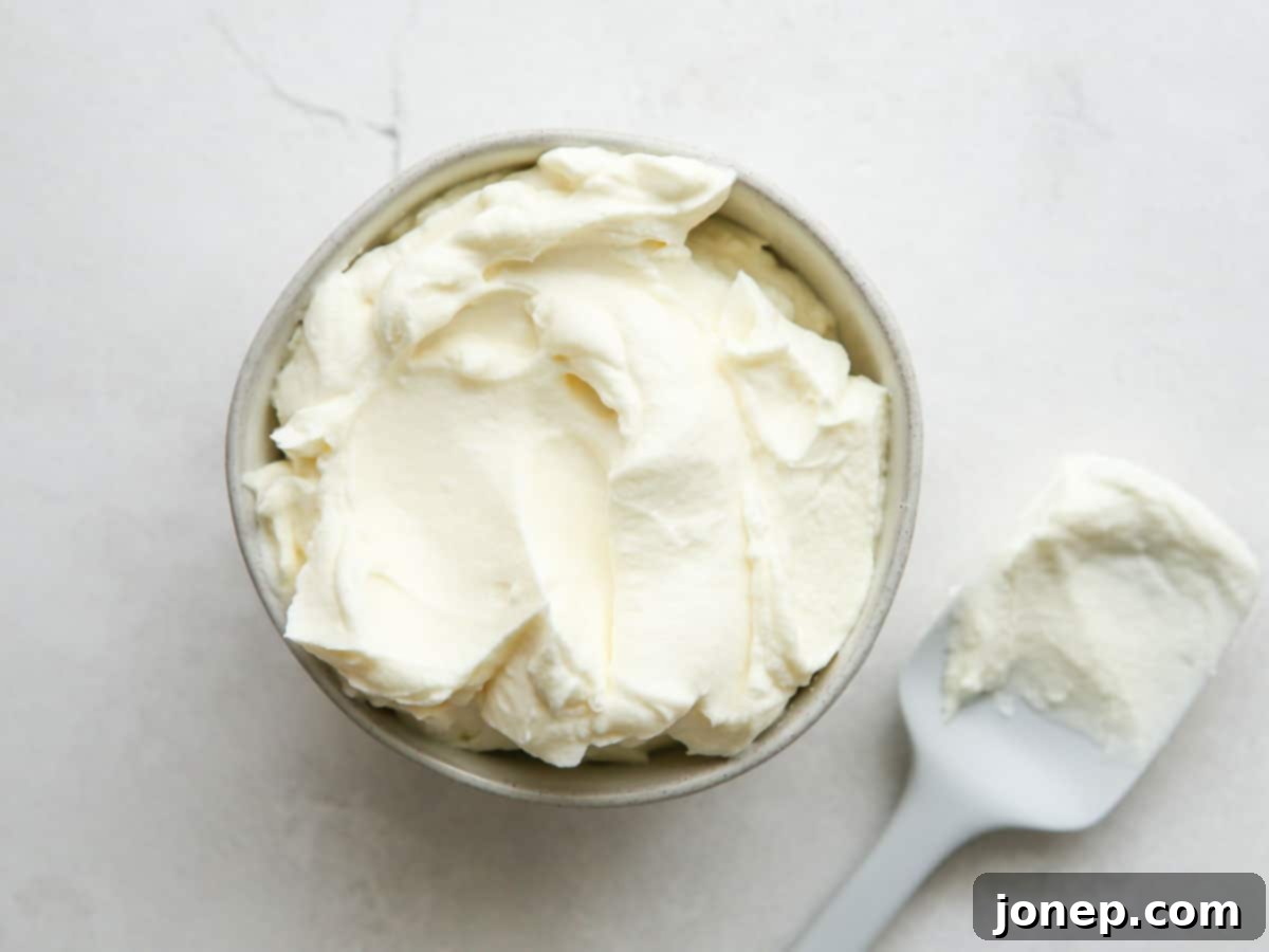 Vanilla buttercream frosting being prepared in a stand mixer.