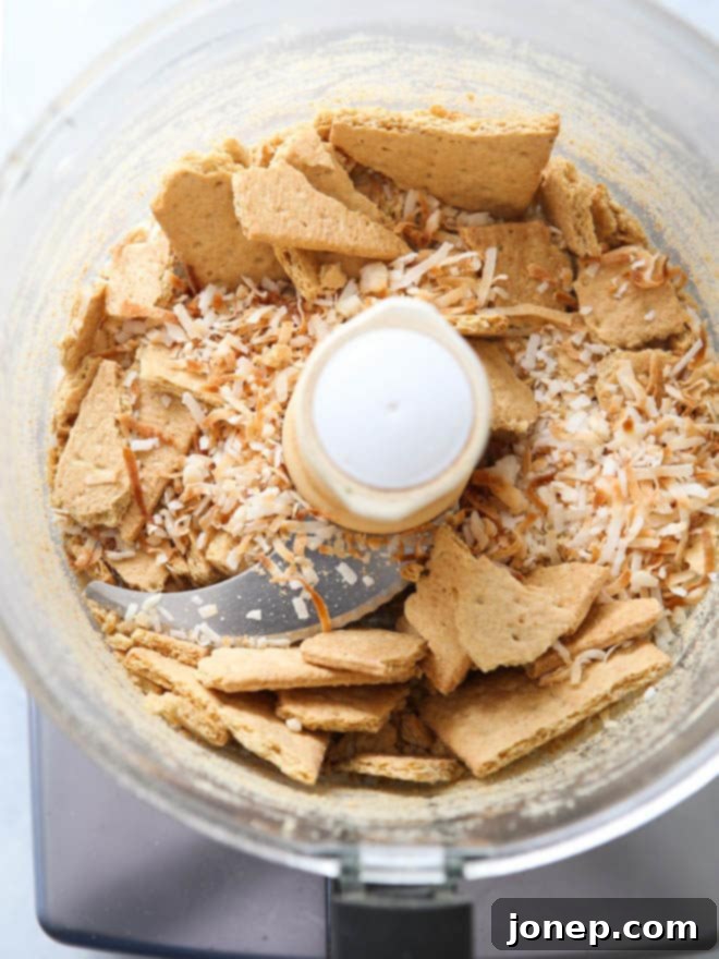 Hands preparing the coconut graham cracker crust for a no-bake pie.