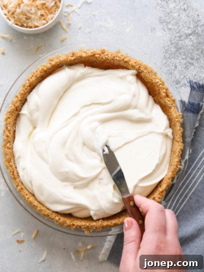 Prepping the creamiest no-bake coconut cream pie with shredded coconut.