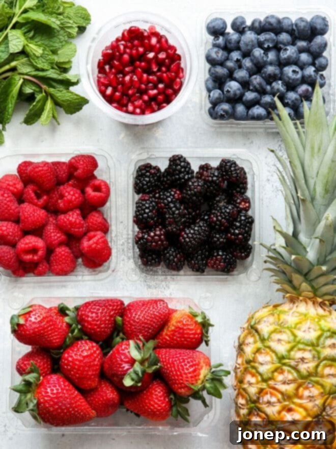 Luscious Berry Fruit Salad 3 Assortment of fresh fruits and berries, including strawberries, blueberries, and pineapple, in preparation for a fruit salad.