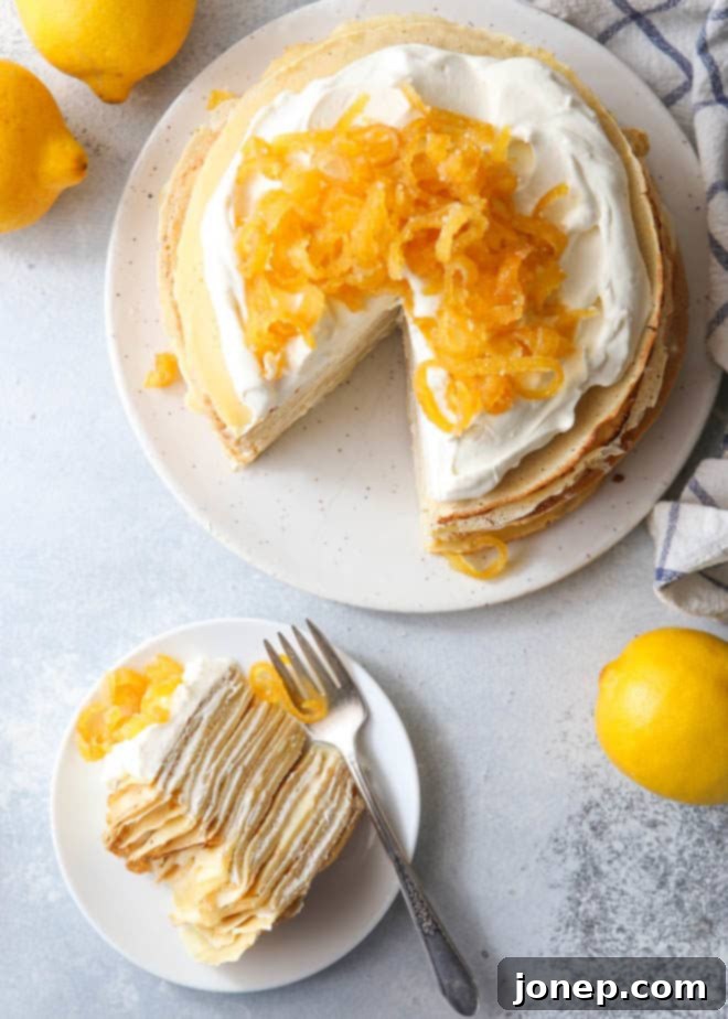 A perfectly cut slice of Lemon Mascarpone Crepe Cake, revealing the beautiful layers of crepes, lemon curd, and mascarpone cream