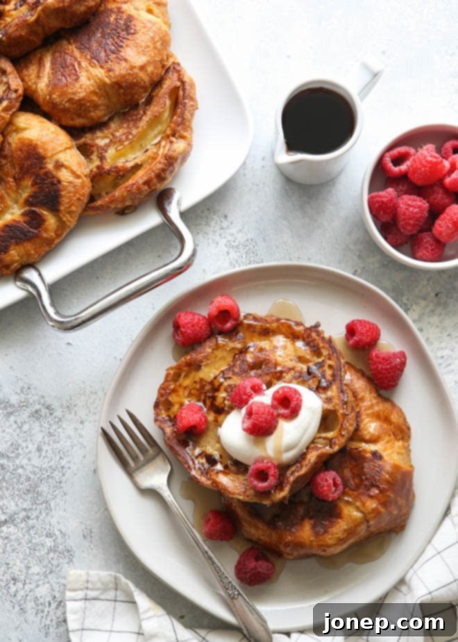 Rich and luxurious croissant French toast drizzled with maple syrup and topped with fresh berries