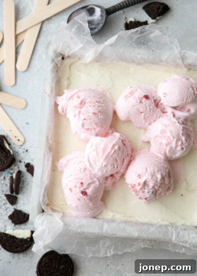 Close-up shot showing the distinct layers of Oreo cookie crust, chocolate ice cream, vanilla ice cream, and strawberry ice cream in a Neapolitan pop, highlighting its delightful texture and vibrant colors.