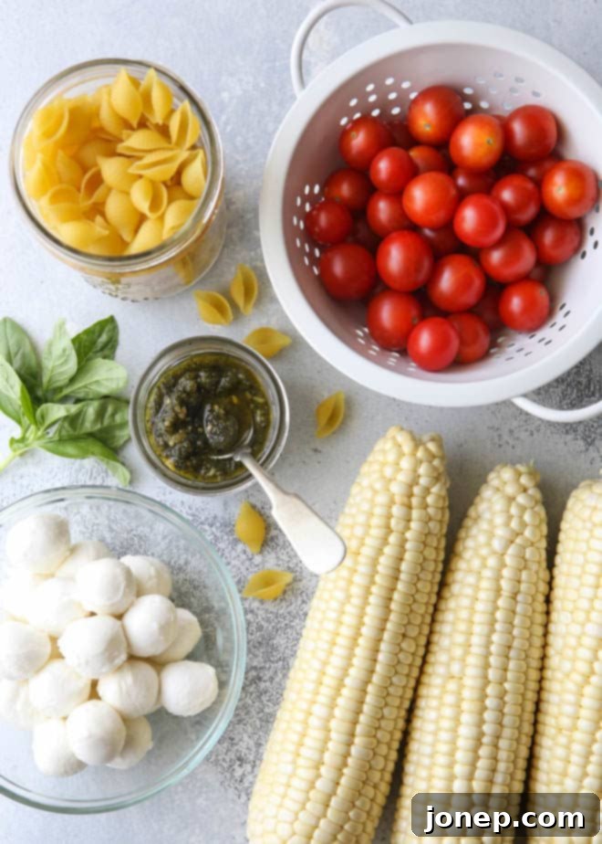 All of the ingredients for fresh corn, tomatoes, pesto and mozzarella salad