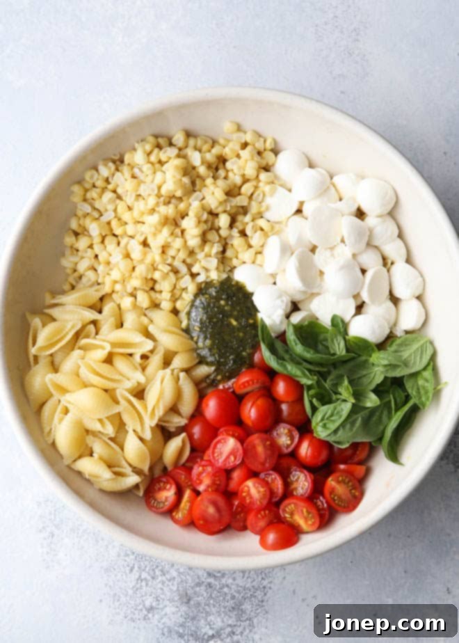Making fresh corn, tomatoes, pesto and mozzarella salad