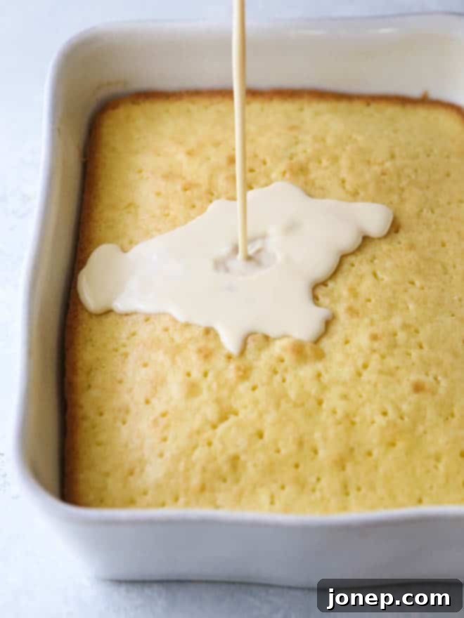 Preparation stages of Tres Leches cake, showing the baked cake being meticulously poked with holes using a fork to ensure maximum milk absorption.