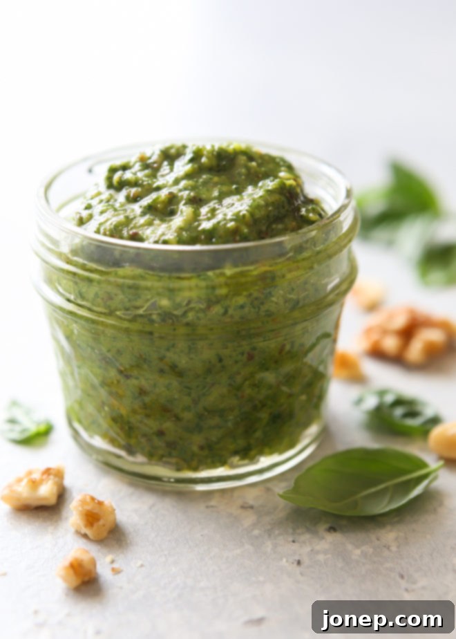 A bowl of fresh basil walnut pesto, ready to be used, showcasing its vibrant green color.
