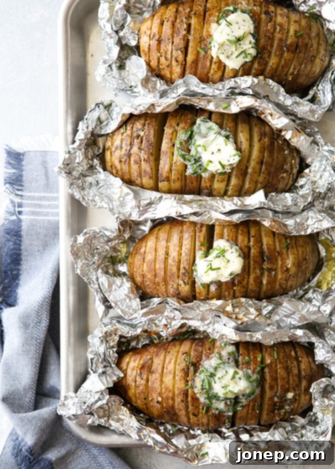 Perfectly 'baked' potatoes cooked on the grill, fanned out and served with a generous dollop of chive butter melting into the cuts.